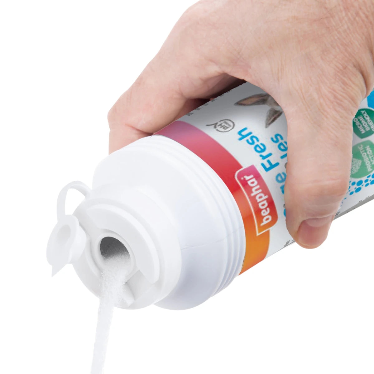 Persona aplicando los granos del neutralizador Beaphar sobre el lecho de la jaula para absorber malos olores y mejorar la higiene.