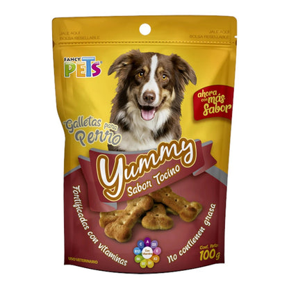 Empaque de 100g de galletas Yummy sabor tocino de Fancy Pets, resaltando que son premios fortificados y sin grasa para perros, en Kamalitas.