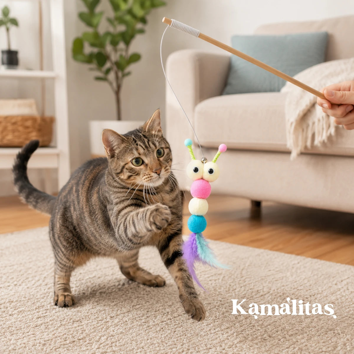 Gato atigrado jugando con varita de peluche con plumas, ideal para estimular el ejercicio, la caza natural y el entretenimiento felino, disponible en Kamalitas.