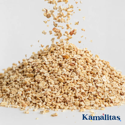 Acercamiento a la textura y caída del grano triturado de maíz 100 por ciento natural, ideal para crear un suelo seguro, cómodo y absorbente en jaulas de aves o roedores, en Kamalitas.