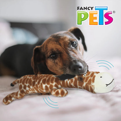 Perro café de tamaño mediano acurrucado en su cama con la jirafa de peluche Mega Buddy como objeto de apego y confort.