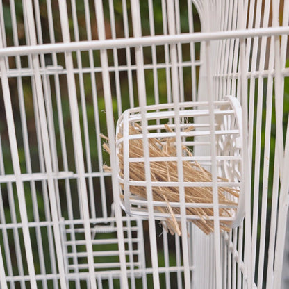 Porta pelero de plástico blanco con yute instalado y colgado correctamente en los barrotes de una jaula blanca, mostrando su funcionalidad, en Kamalitas.