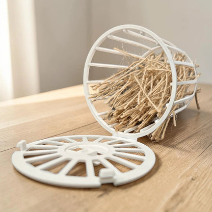 Canasta plástica blanca porta pelero abierta mostrando el relleno de yute natural sobre una mesa de madera, resaltando su tapa con bisagra, en Kamalitas