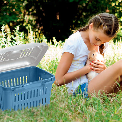 Niña en el campo con un conejo y transportadora MIDI Gulliver azul abierta, ventilada y cómoda para pequeños animales.