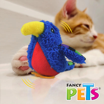 Gatito naranja relajado junto a su loro azul de peluche, demostrando su función como juguete de compañía y apego.